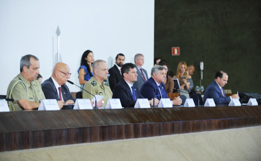 Participants seated at a parliamentary meeting table.