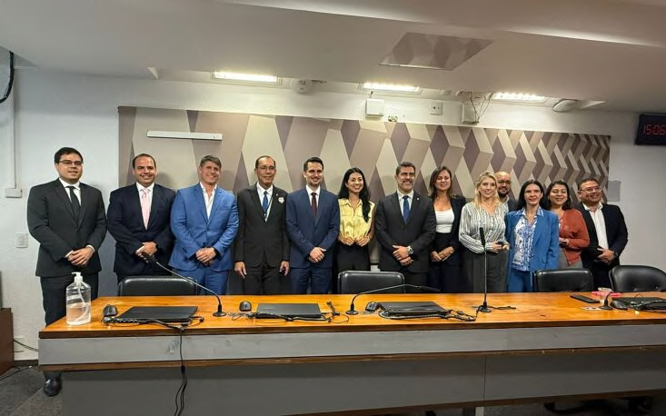 Group standing beside a committee room table.