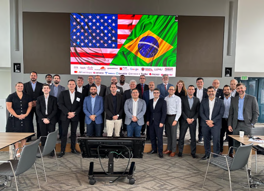 Delegation in front of a screen displaying the Brazilian and US flags.